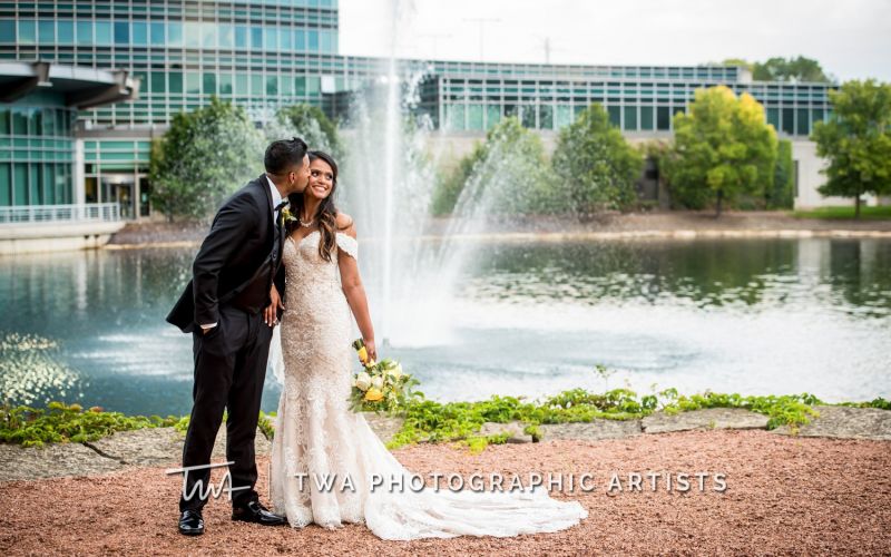 Bride and groom with water feature in background.